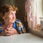 senior woman looking out of a window