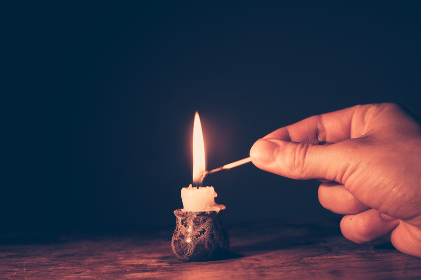 lighting a candle with a match