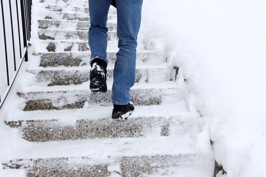 man walking up snow covered stairs