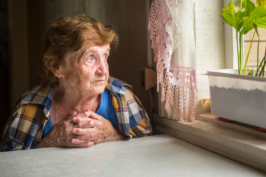 senior woman looking out of a window